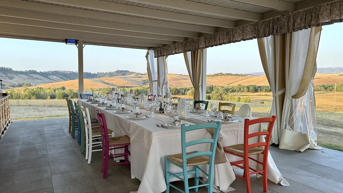 Long wedding table in the covered hall, open onto the Tuscan landscape